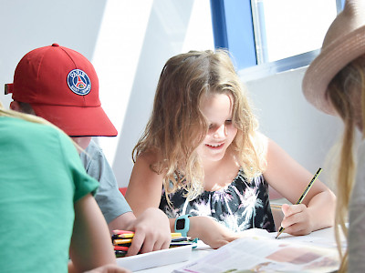 lapset pöydän ääressä taiteilemassa